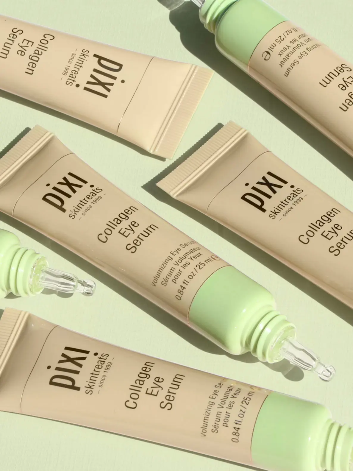 Image of six eye creams in mint green and beige tubes