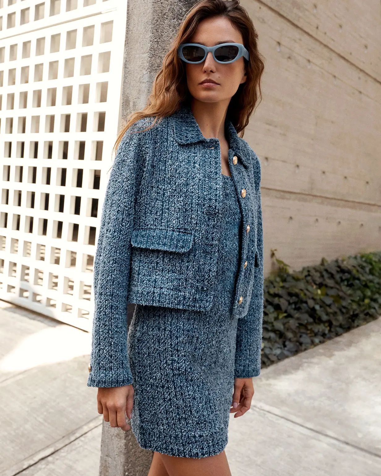 Woman wearing blue tweed-style jacket and matching dress