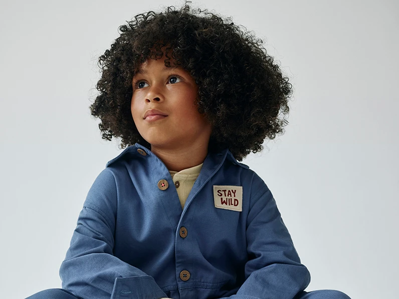 Boy wearing blue boiler suit from the M&S x Binky collection