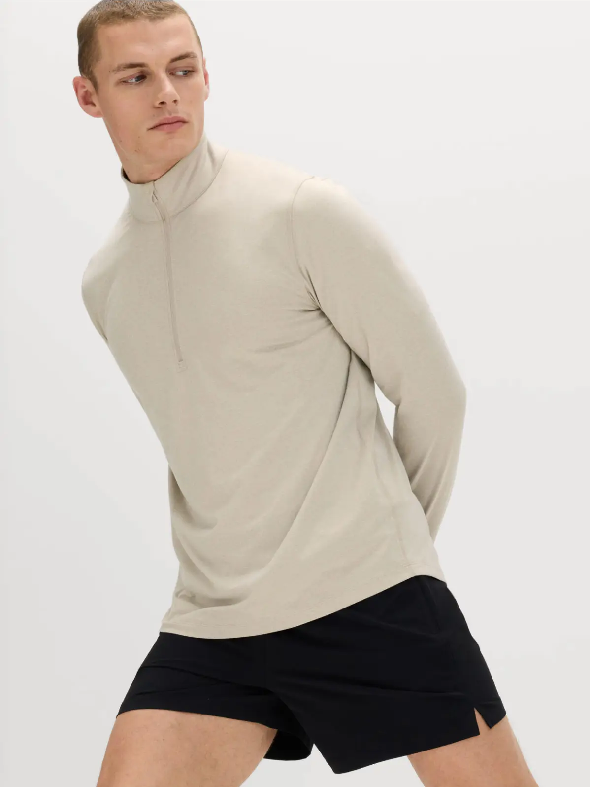 Man wearing cream running top and black shorts 