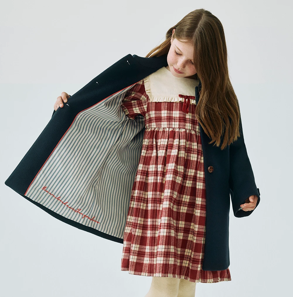 Girl showing the interior lining of a coat from the M&S x Binky collection