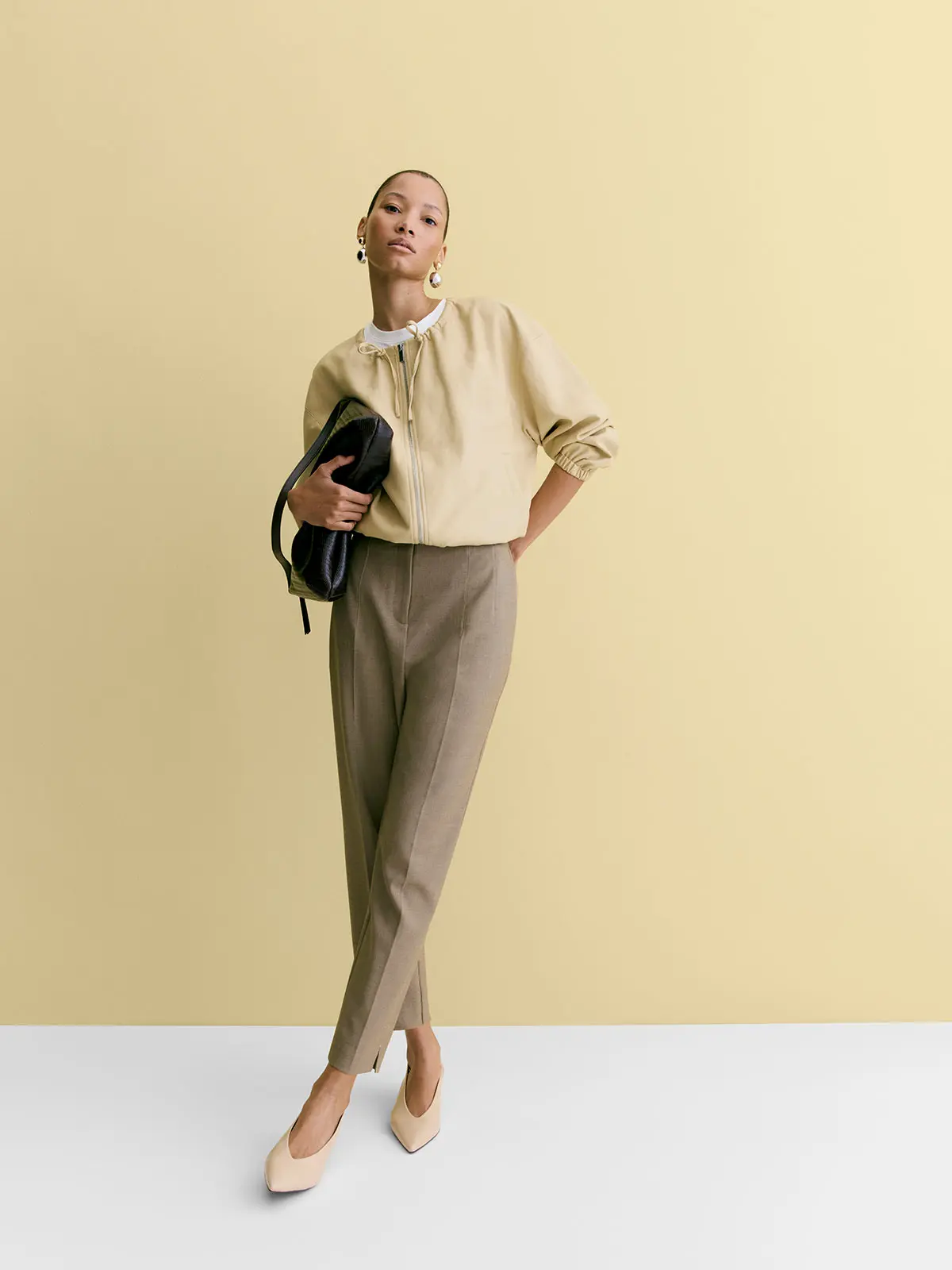 Woman wearing yellow jacket, smart trousers and heels 