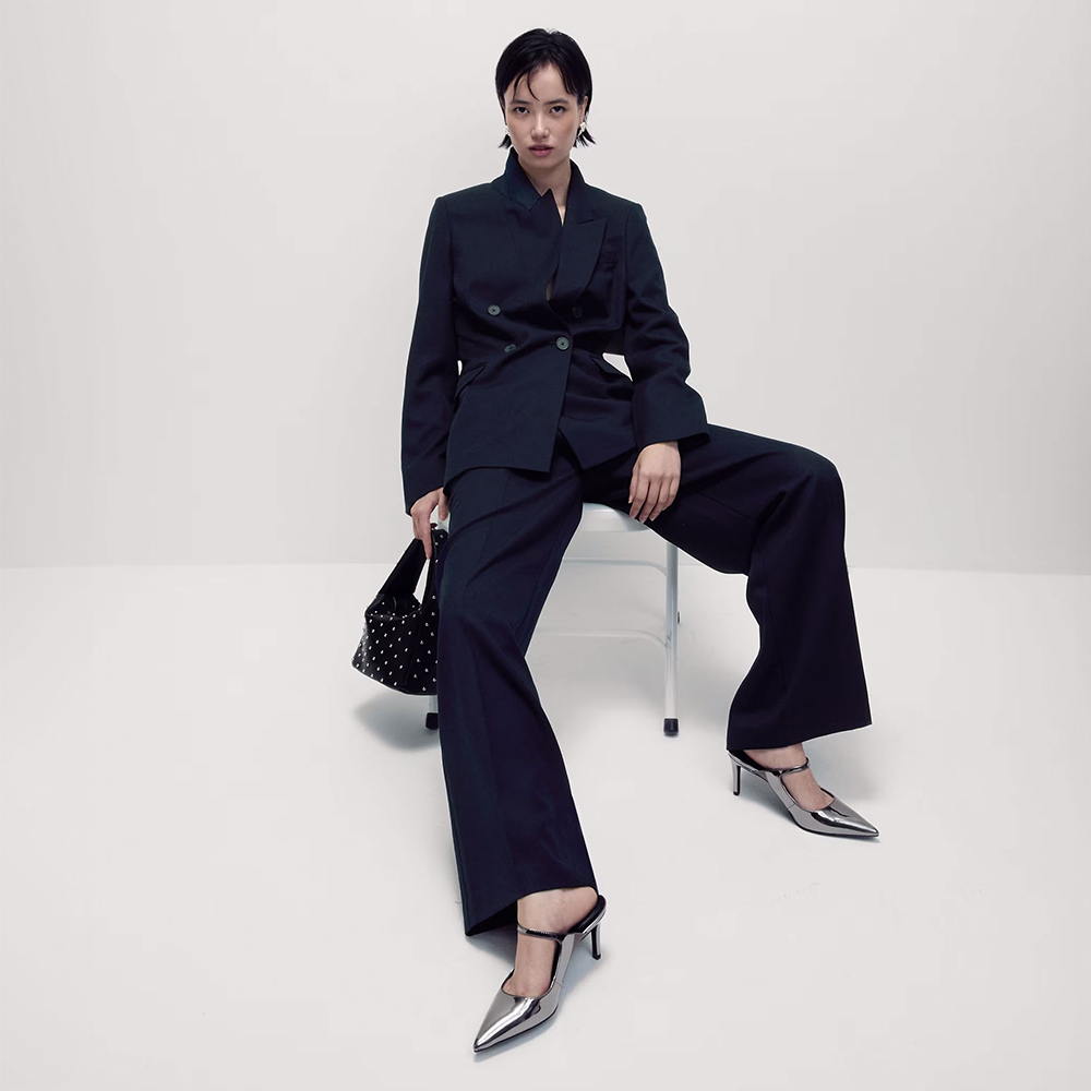 Woman wearing navy trouser suit and silver pointed shoes