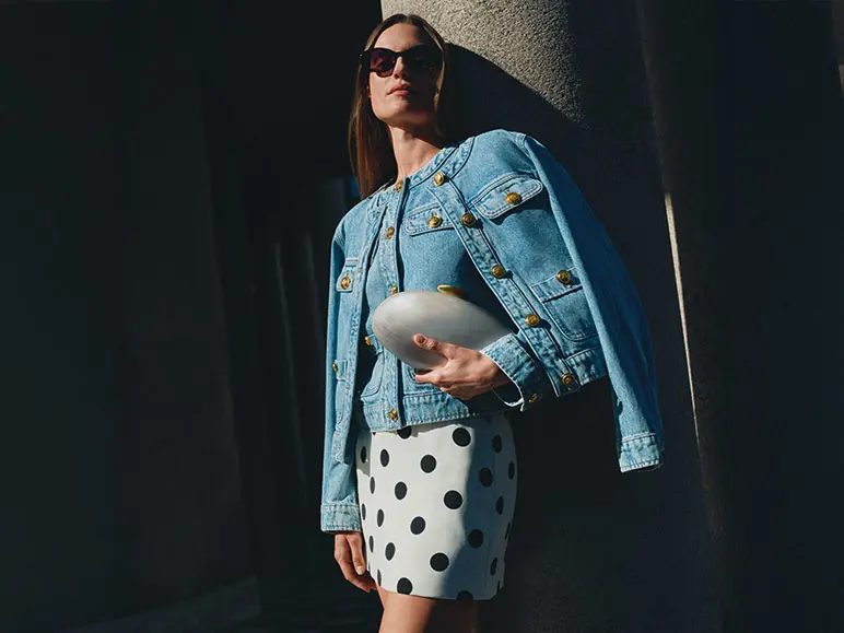 Woman wearing polka dot skirt and denim jacket