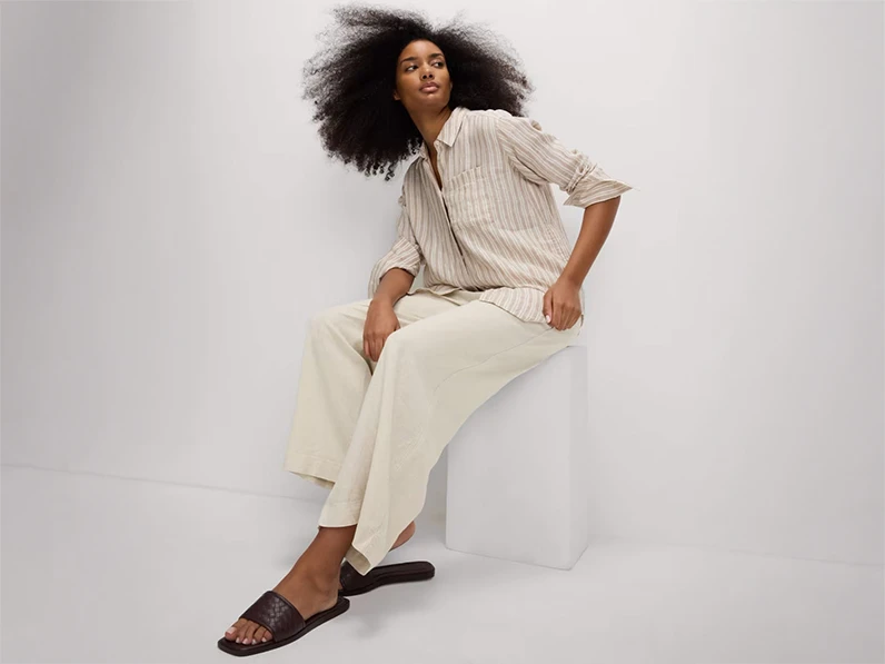 woman wearing striped linen shirt with cream linen trousers and sliders