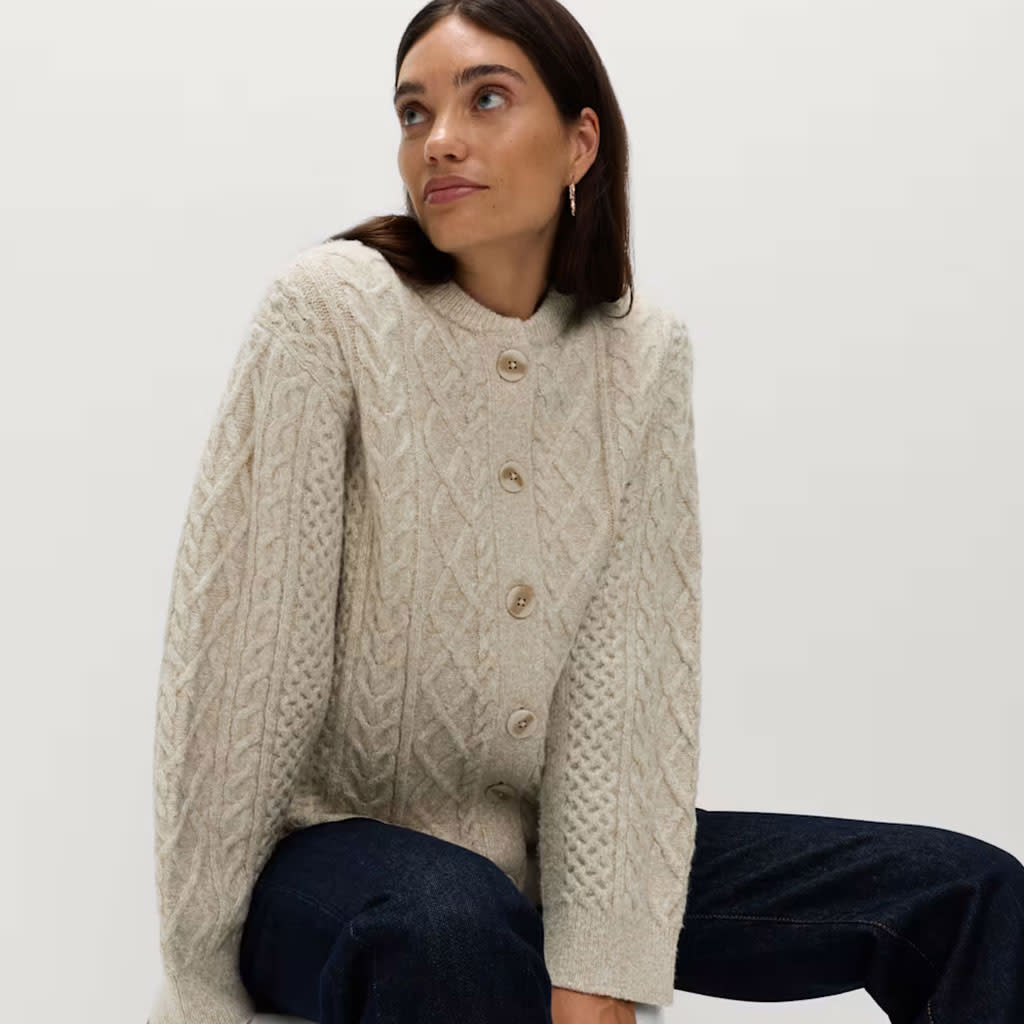 Woman wearing cream cable knit cardigan