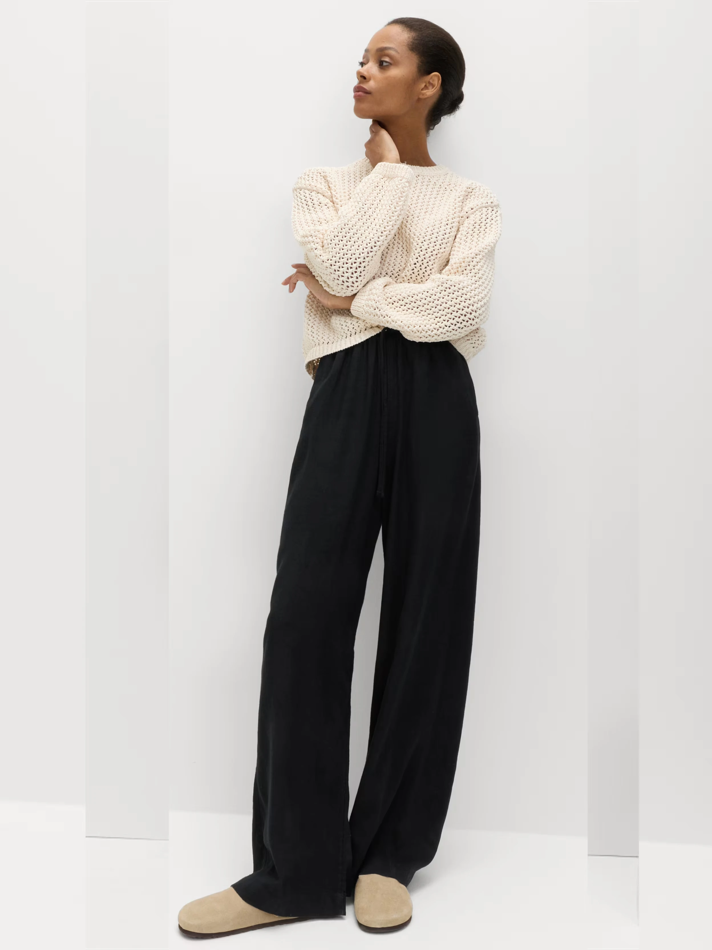 Woman in black trousers and cream jumper