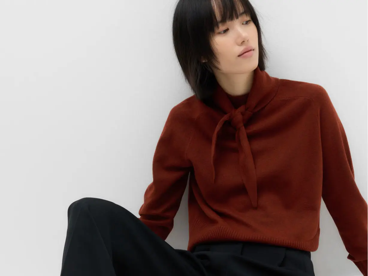 Woman wearing high-neck jumper with tie detail