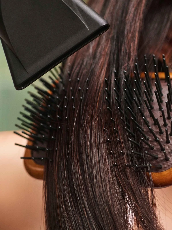 Stylist blow drying hair