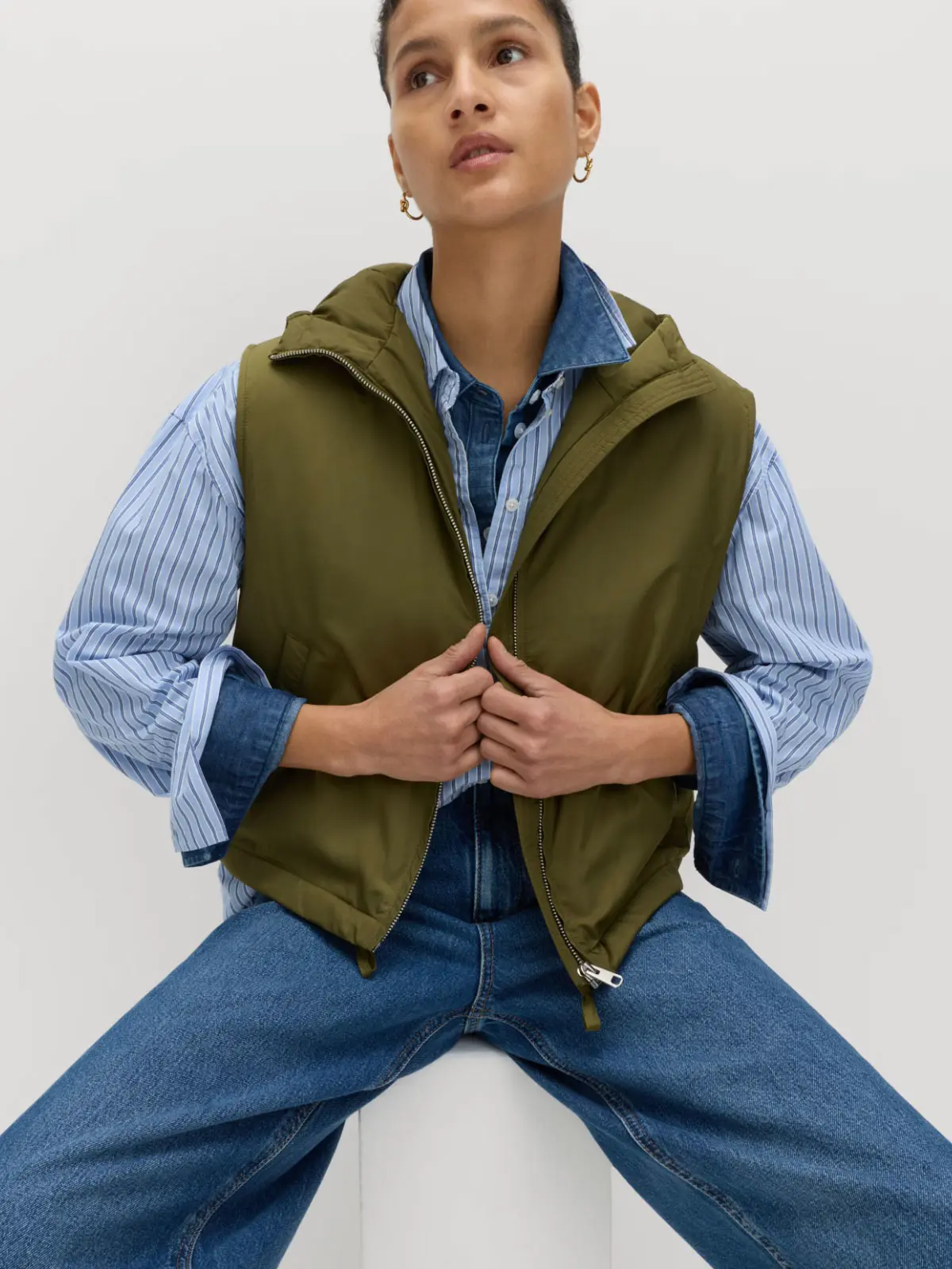 Woman wearing green gilet over layers and blue jeans