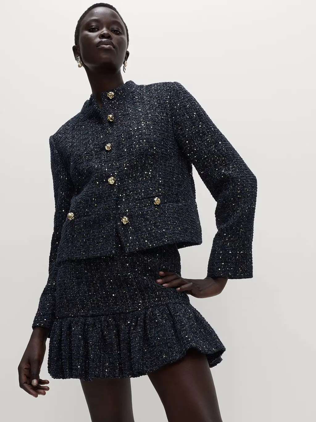 Woman wearing a navy tweed jacket and skirt