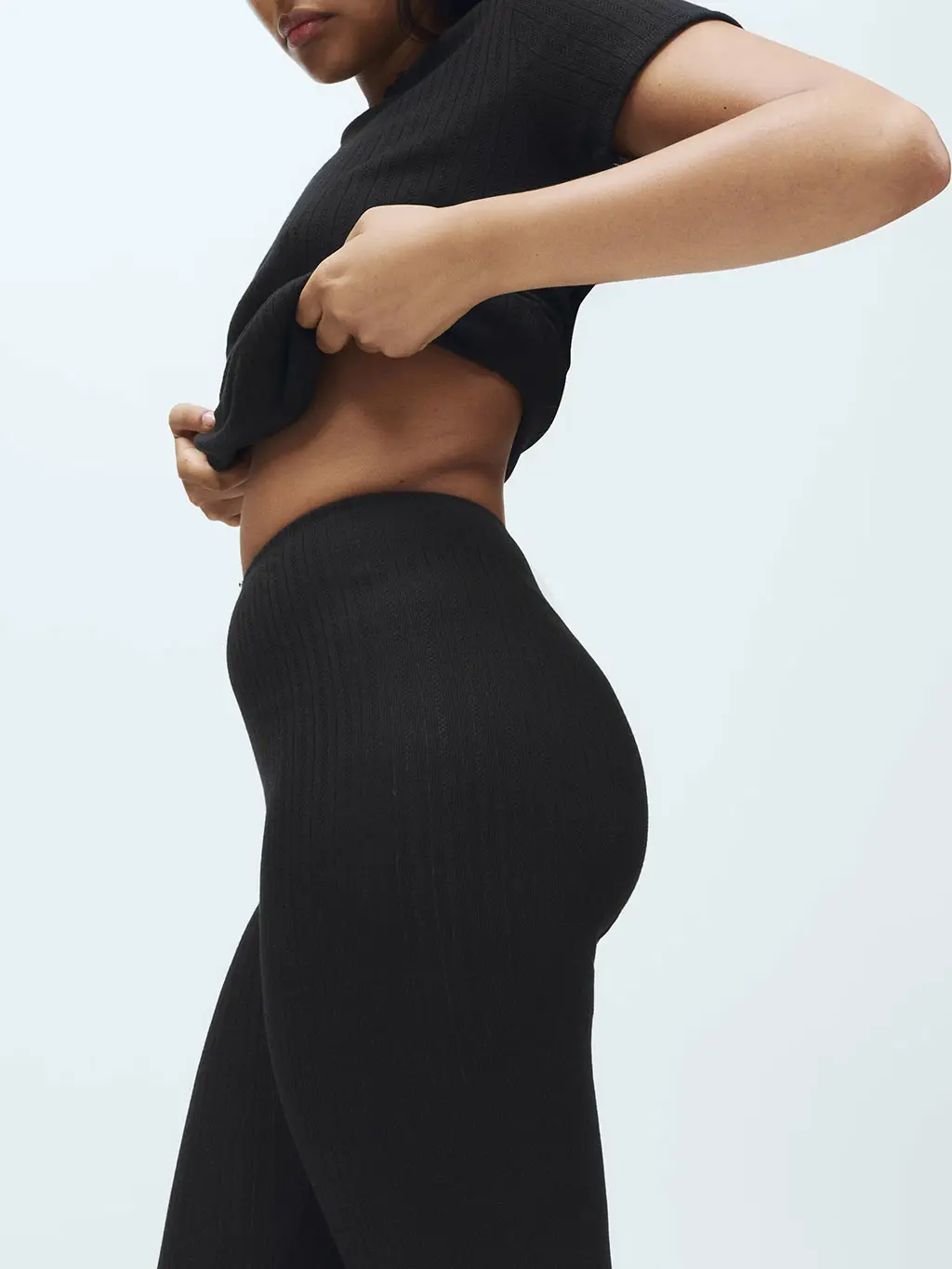 Woman wearing black thermal pointelle leggings and a black thermal top