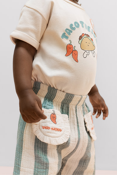 Close of image of baby wearing stripe bottoms and tshirt with taco Tuesday graphic
