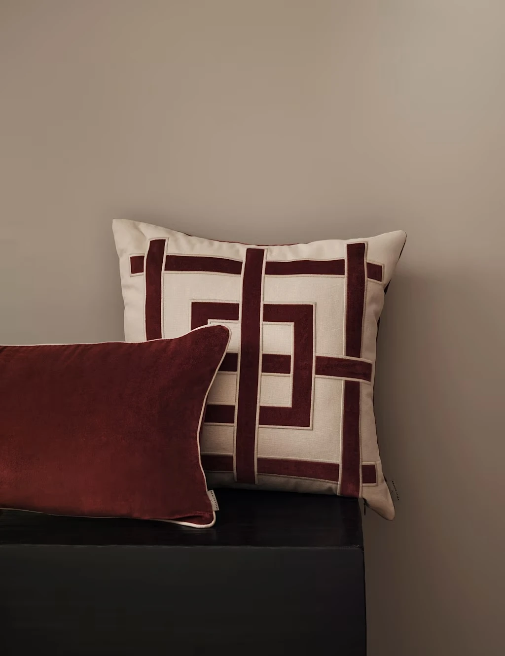 White cotton cushion with a burgundy geometric grid pattern.