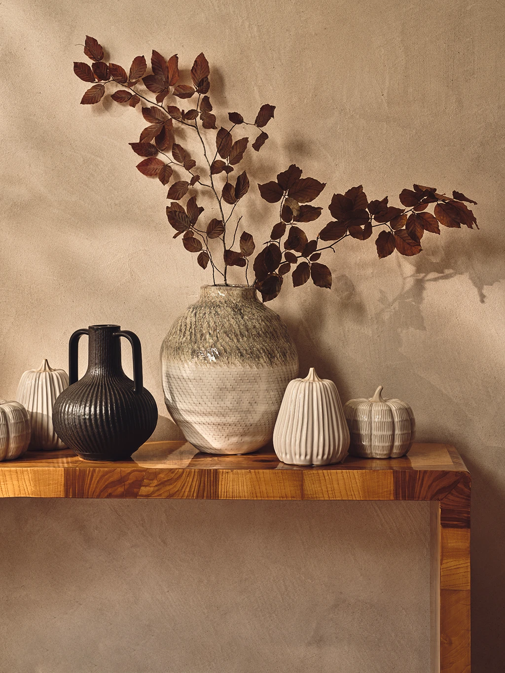 Vases and ceramic pumpkins on a sideboard