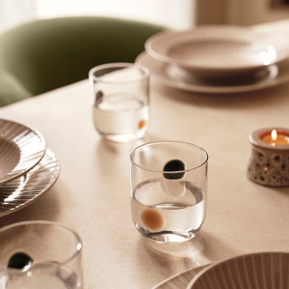 Table set with tablecloth, spotted glasses, tea lights and ceramic dishes