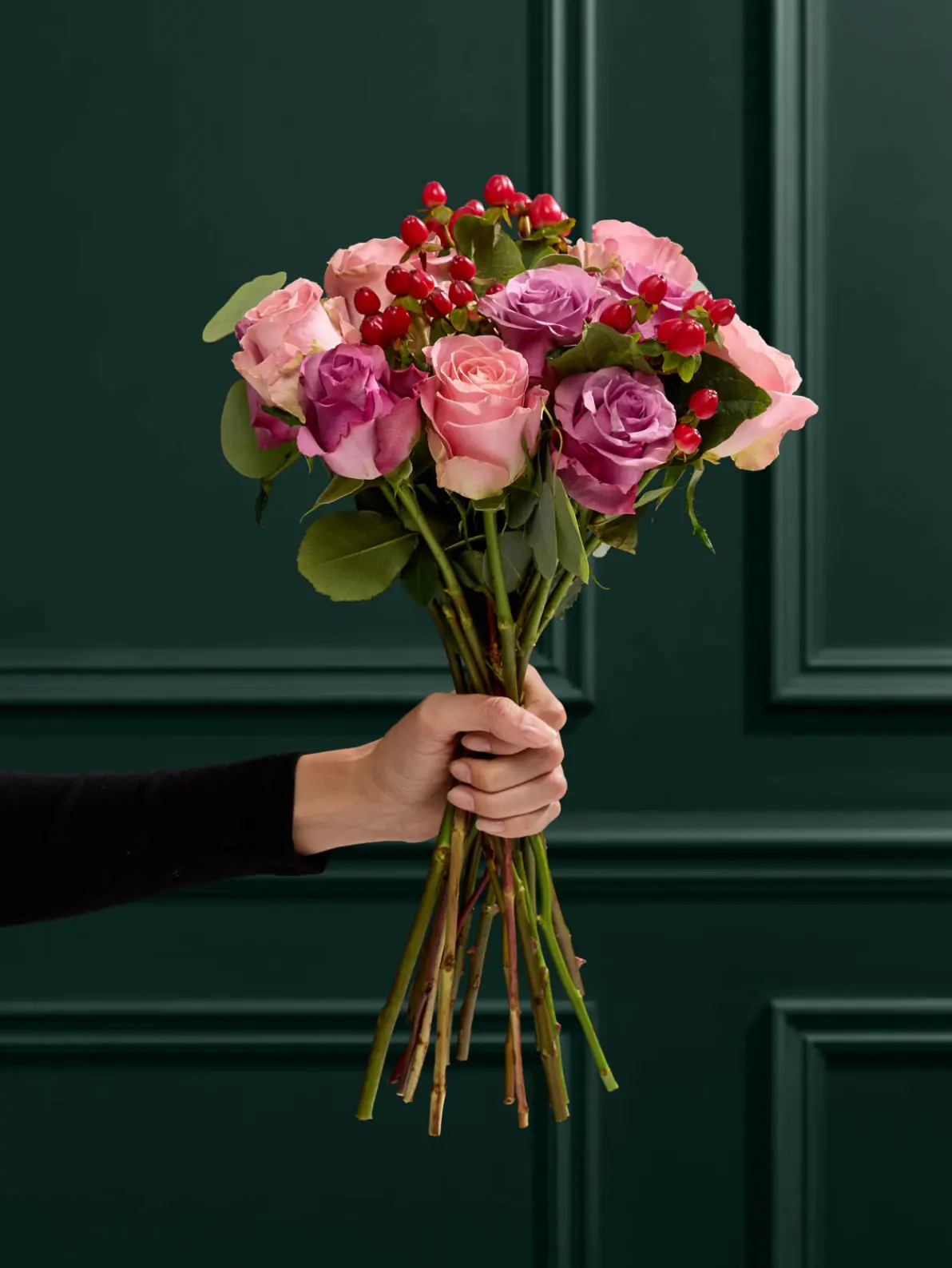 Woman's hand holding a bouquet of pink flowers