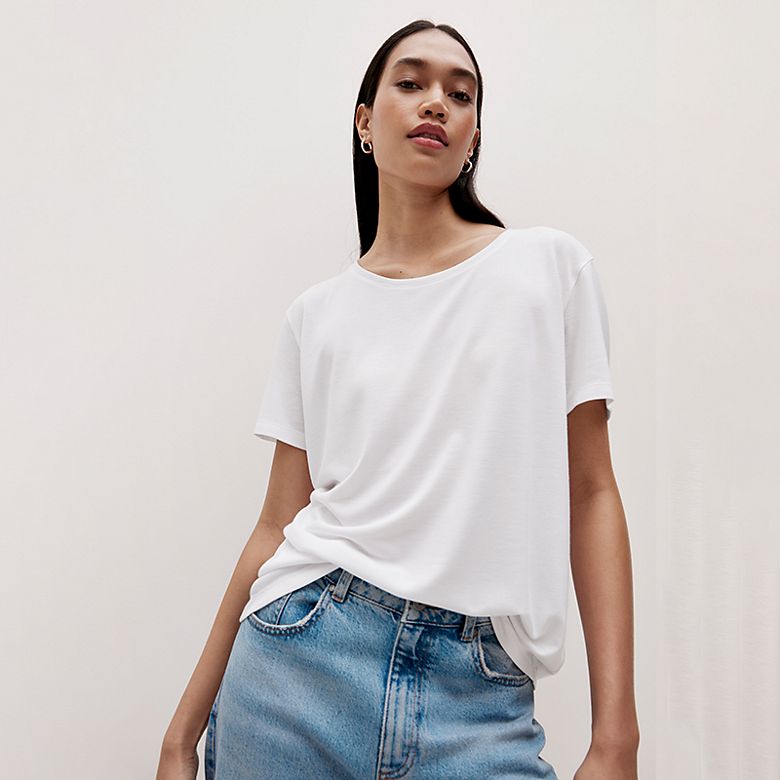 Soft white lightweight T-shirt showing a fluid drape with jeans