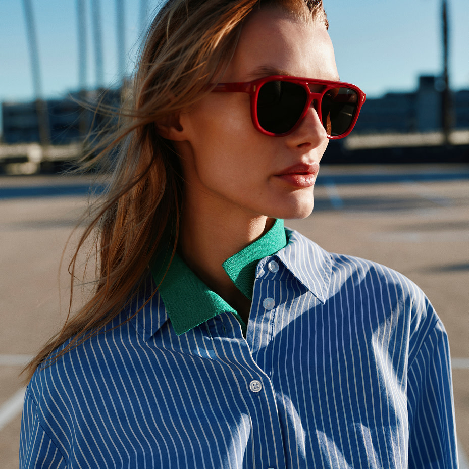 Woman in blue shirt and red sunglasses