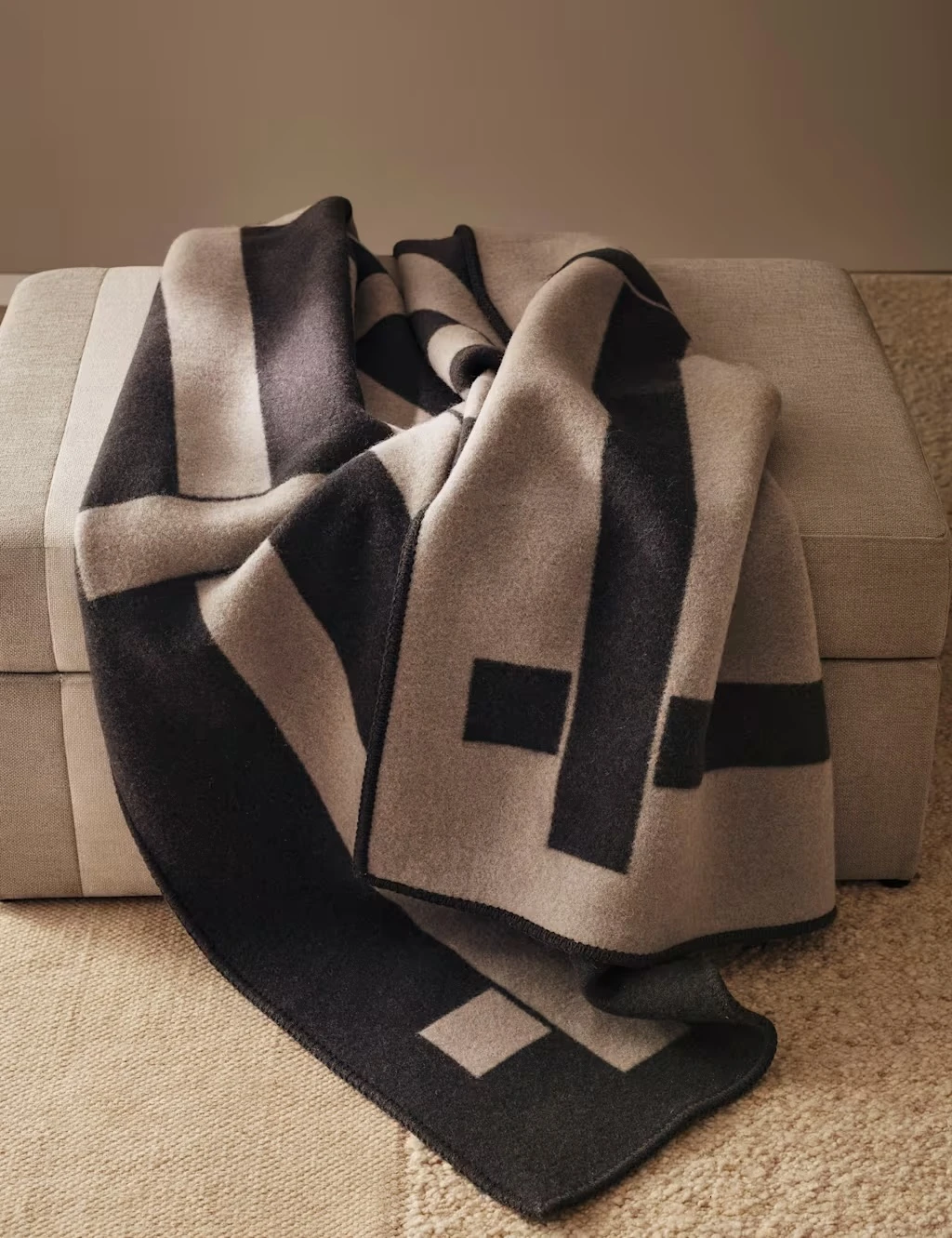Tonal brown geometric throw with a striped reversible pattern.