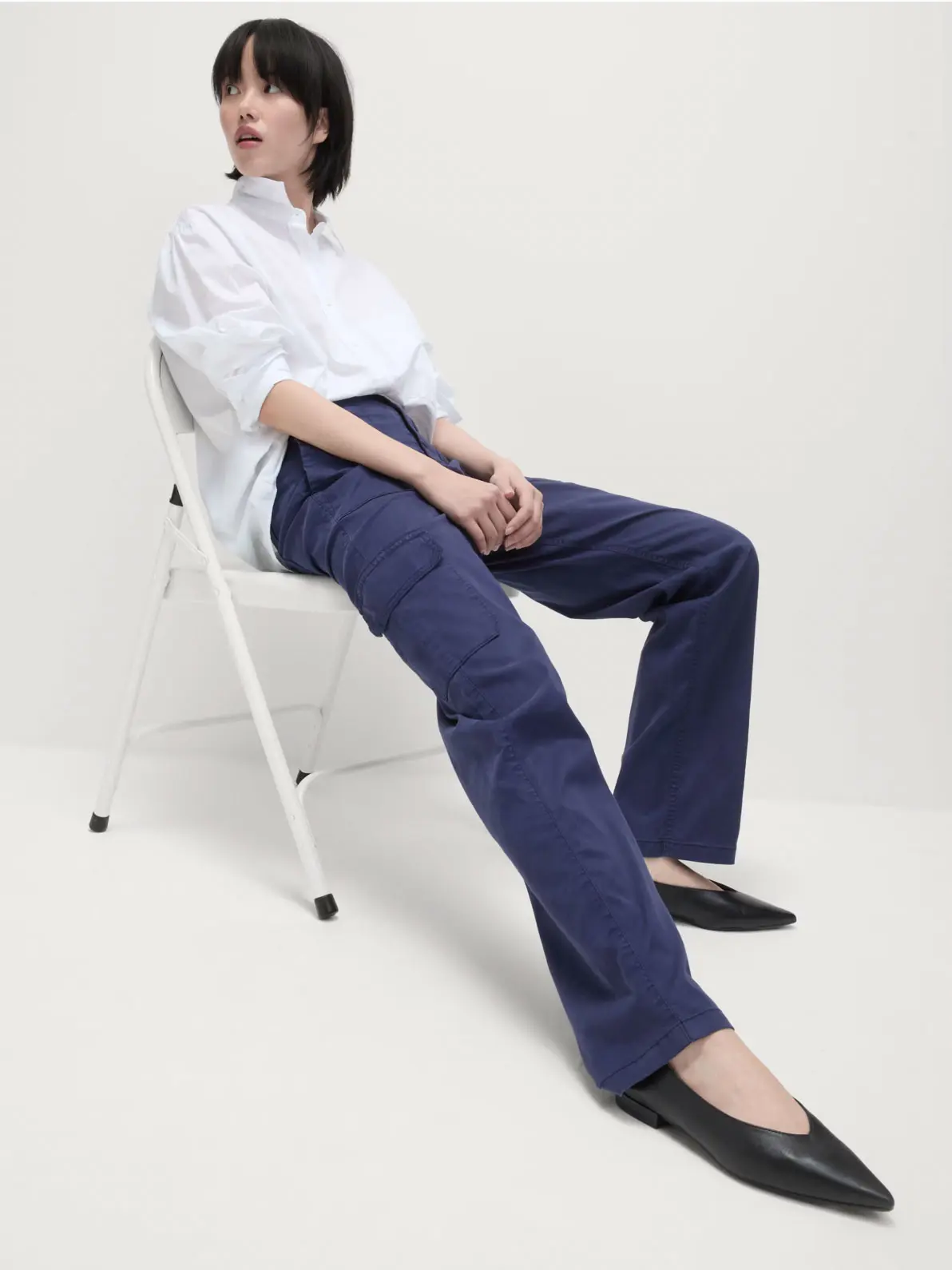 Woman wearing white shirt, navy cargo trousers and black ballet flats
