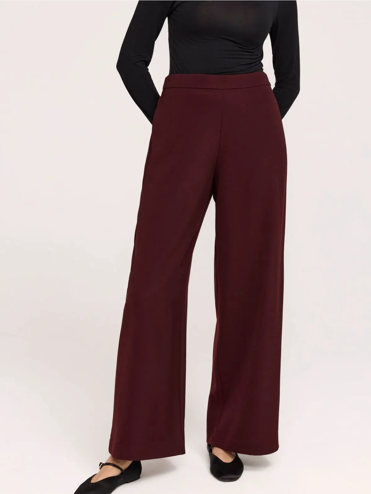 Woman wearing burgundy wide-leg trousers 