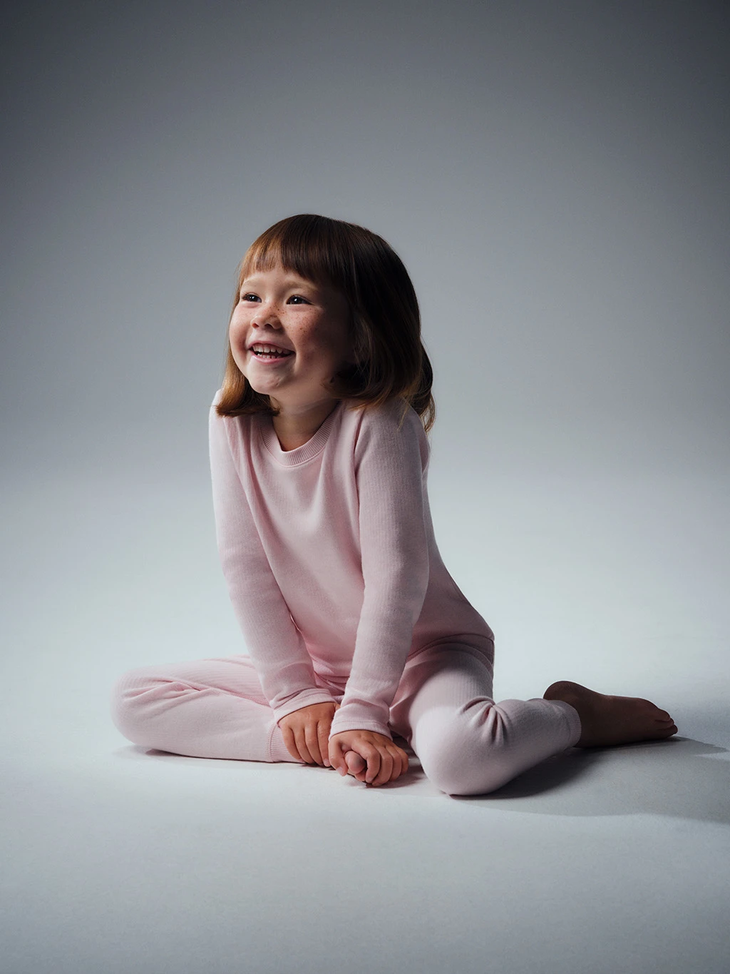 Young girl in a matching pale pink thermal set.