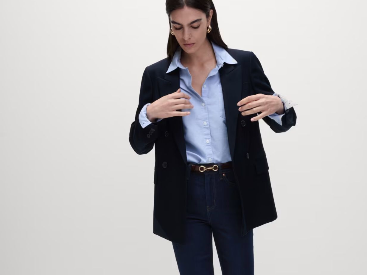 A woman wearing a shirt, blazer and jeans