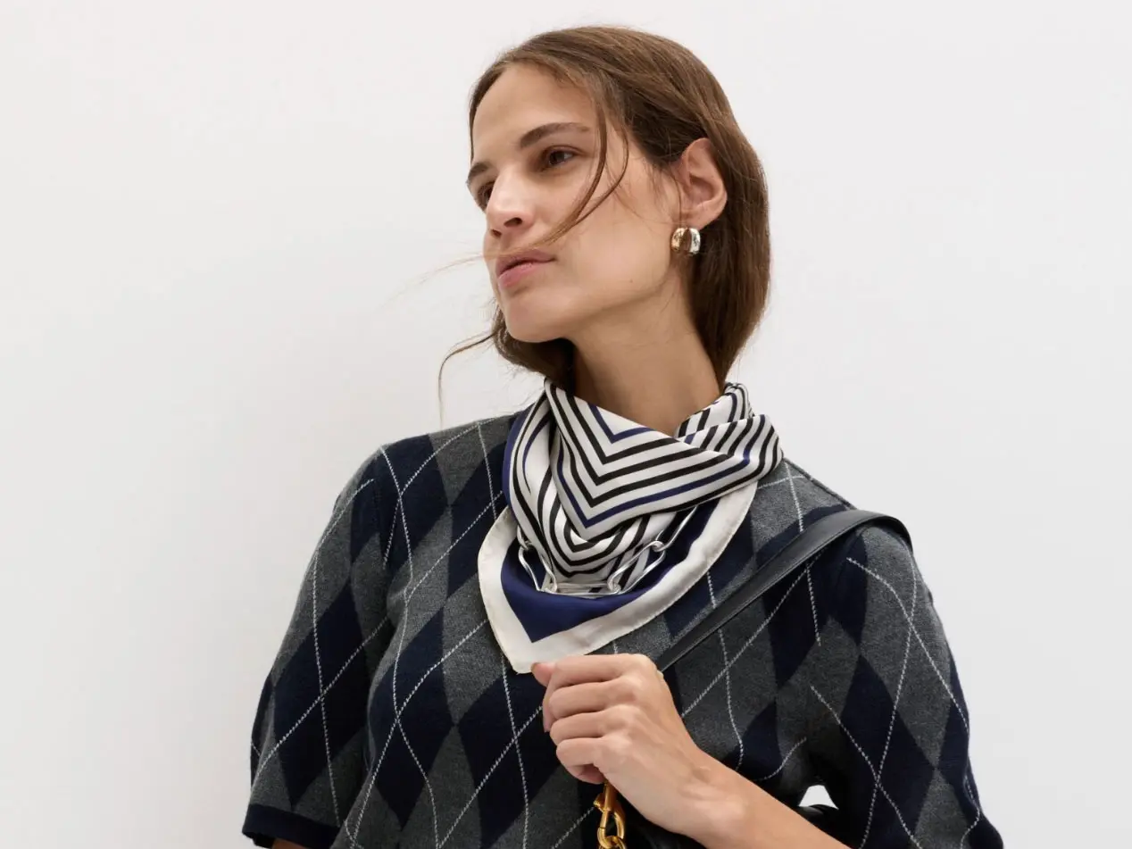 Woman wearing argyle jumper and striped neck scarf