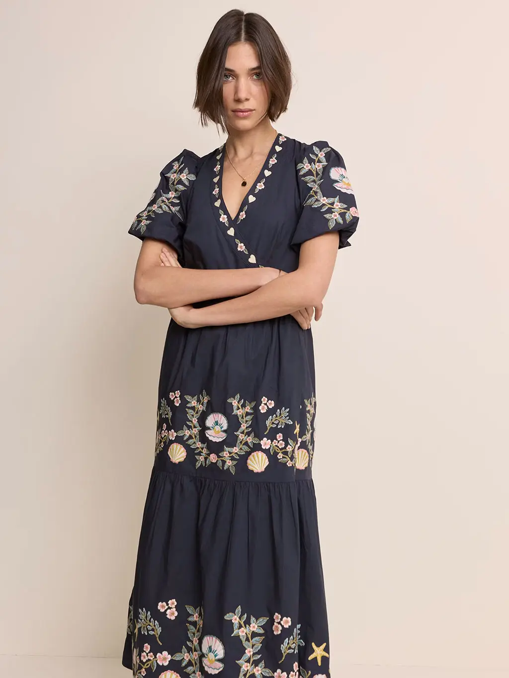 A woman wears a navy floral wrap dress