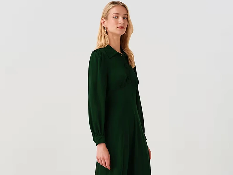 Model wearing a forest green long sleeved dress.