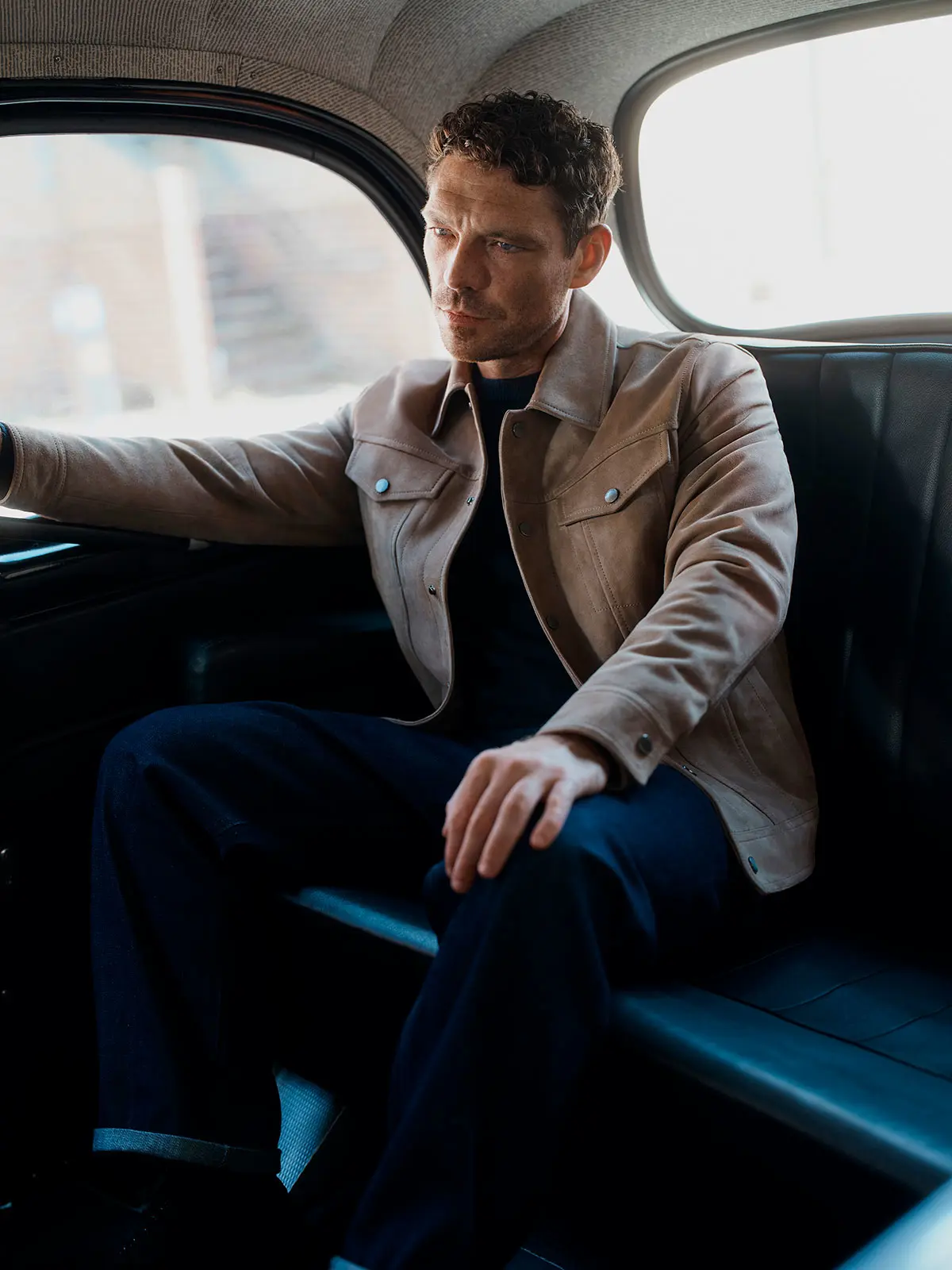 Man sitting in car wearing neutral jacket