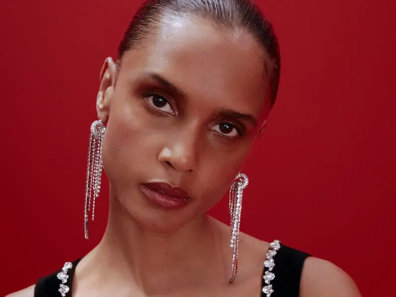 A model has sultry party makeup and is wearing long diamante earrings by M&S