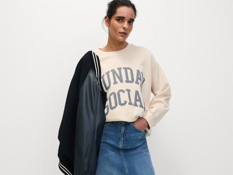 woman wearing cream sweatshirt and denim skirt