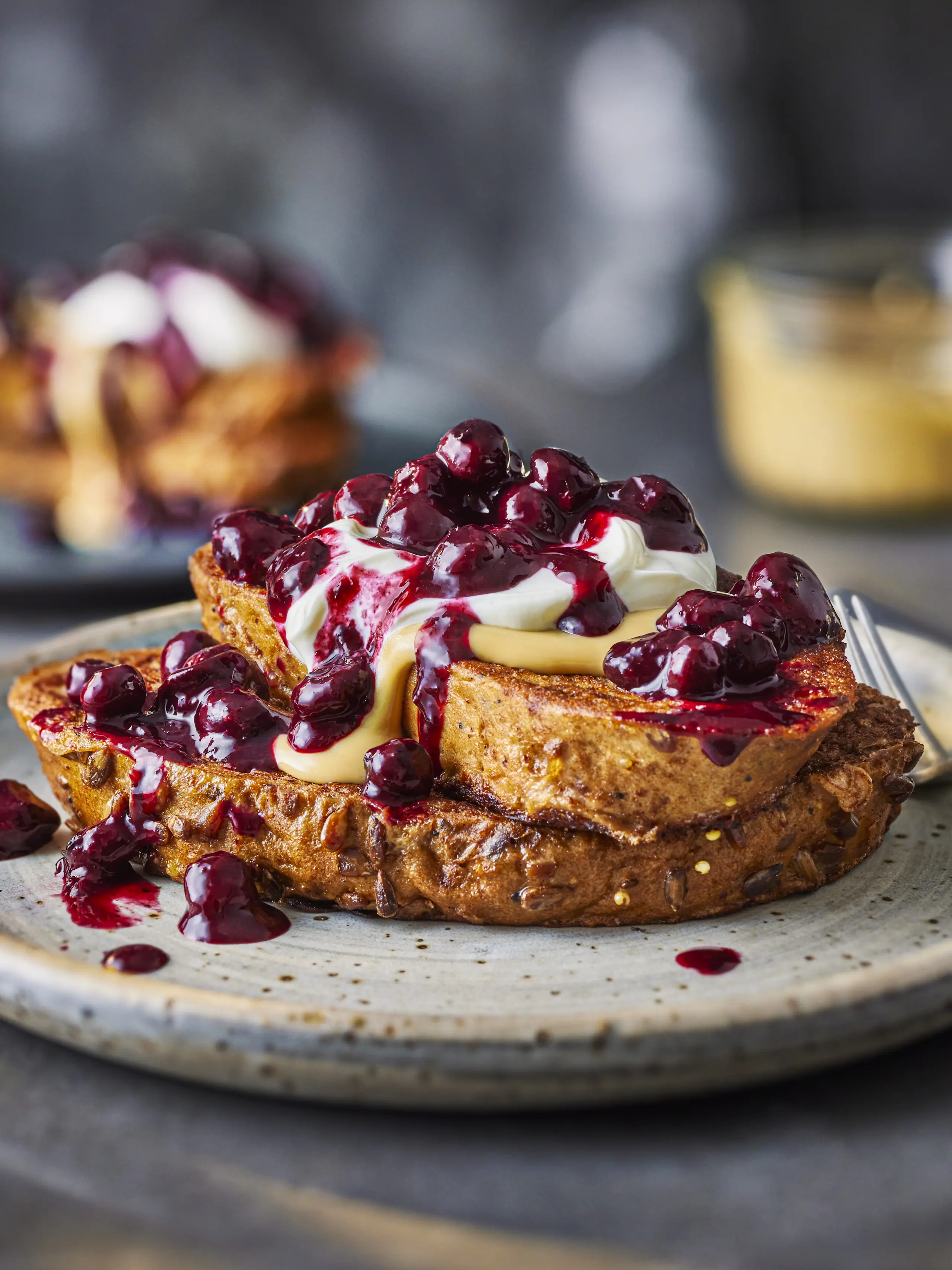 French toast with berry compote on grey plate