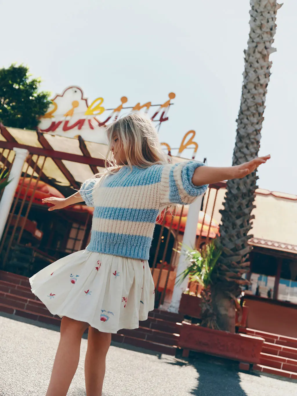 Girl wearing a striped jumper over an embroidered dress