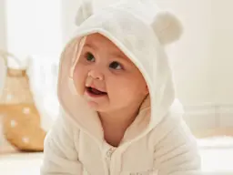 Baby wearing hooded white fleece onesie with ears 