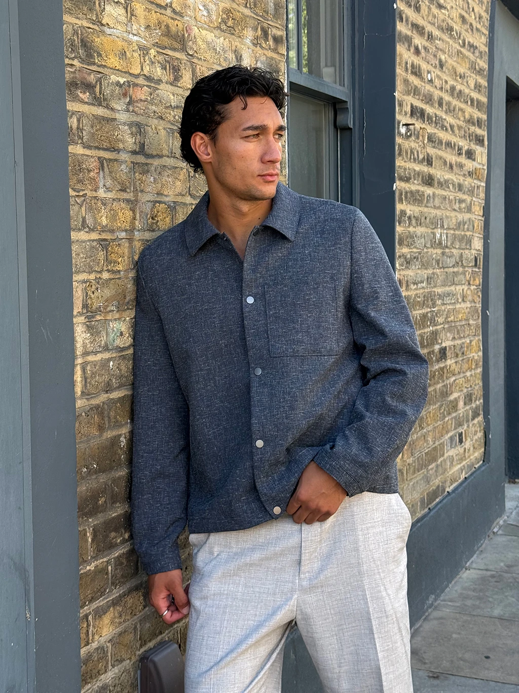 Manawa Owens in navy overshirt and tan trousers