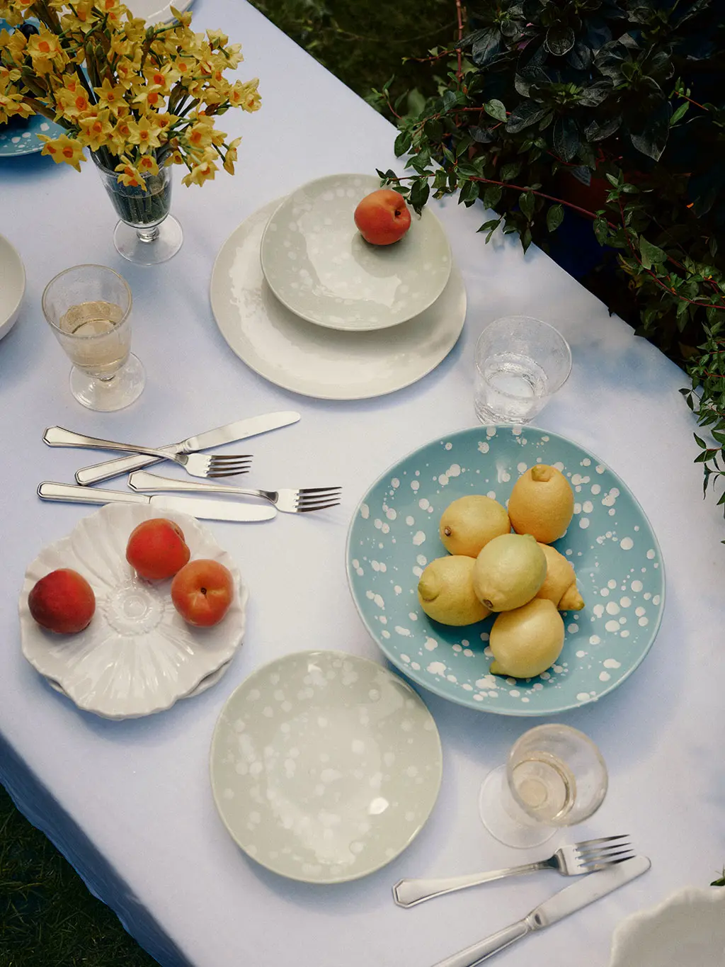 White table with blue plates and bowl of lemons