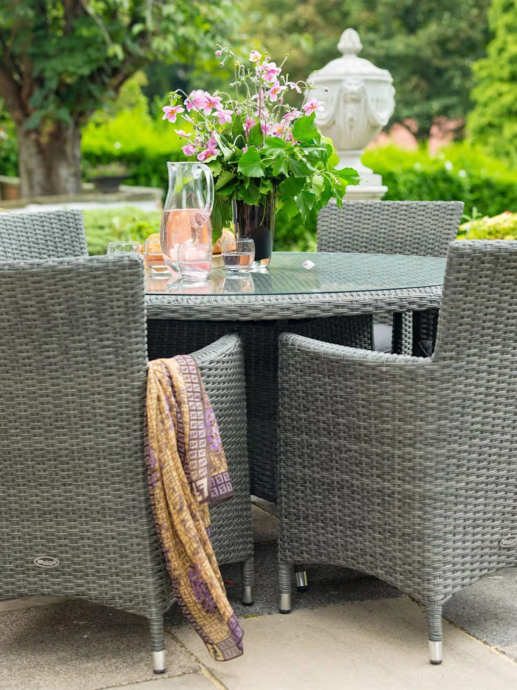 Garden party scene featuring a grey rattan table and chairs