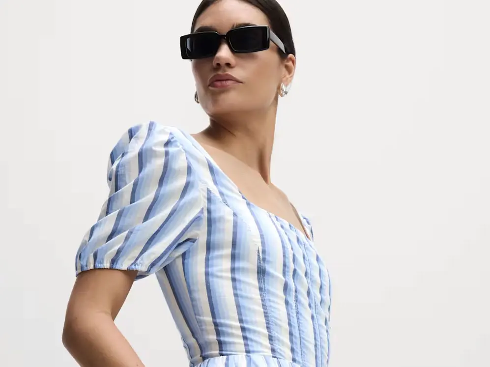 Woman wearing striped dress and black sunglasses