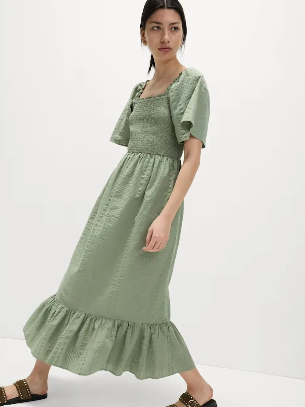 A woman wears a sage green midi dress