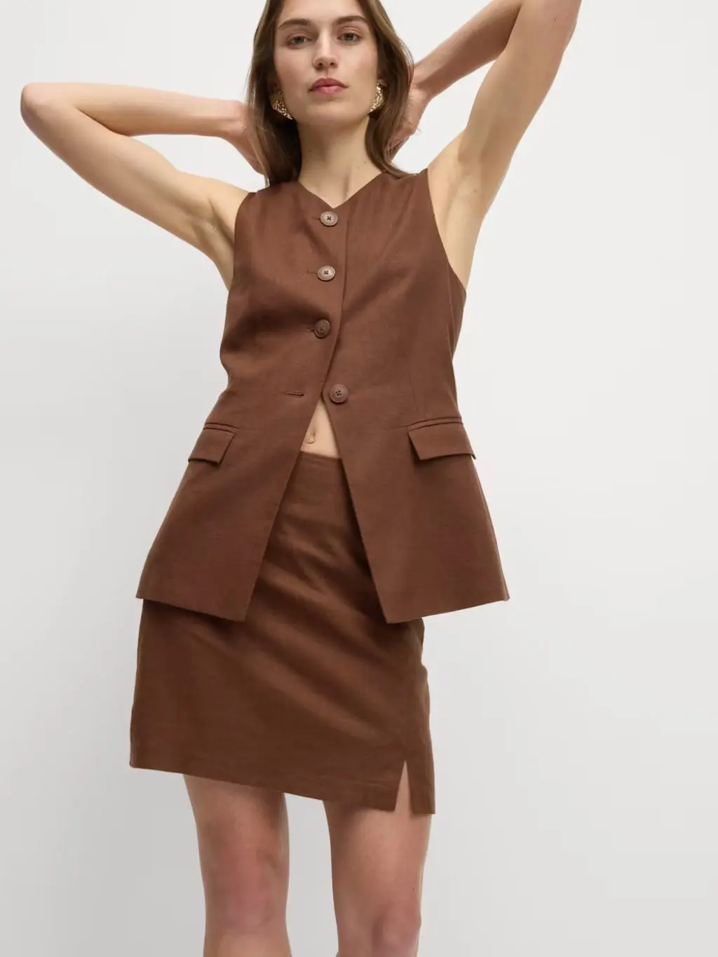 A woman wears a brown waistcoast and matching mini skirt