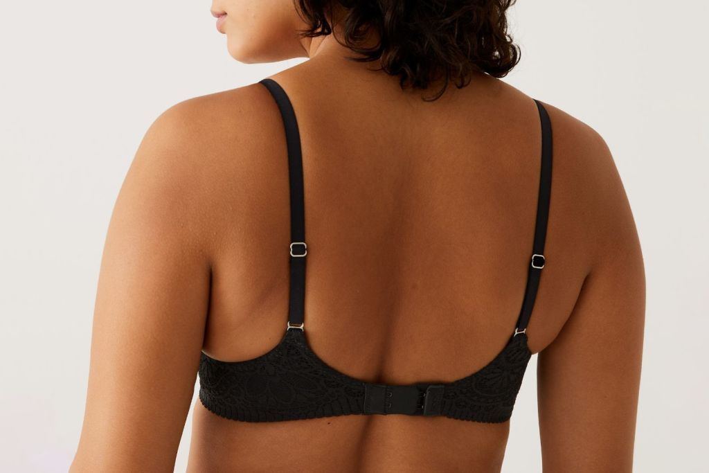 Woman wearing black bra. Shop bras