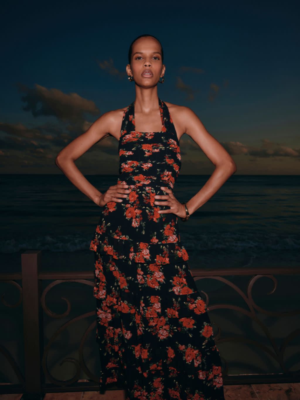 A woman wears a long black and red maxi floral dress