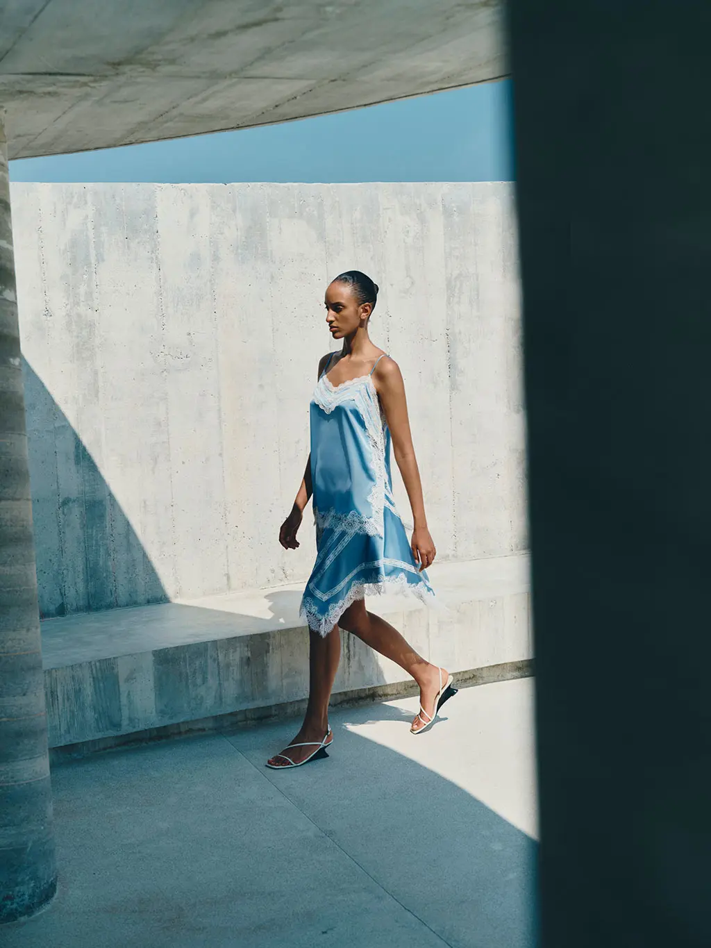 Woman wearing blue satin two-piece set with white lace trims