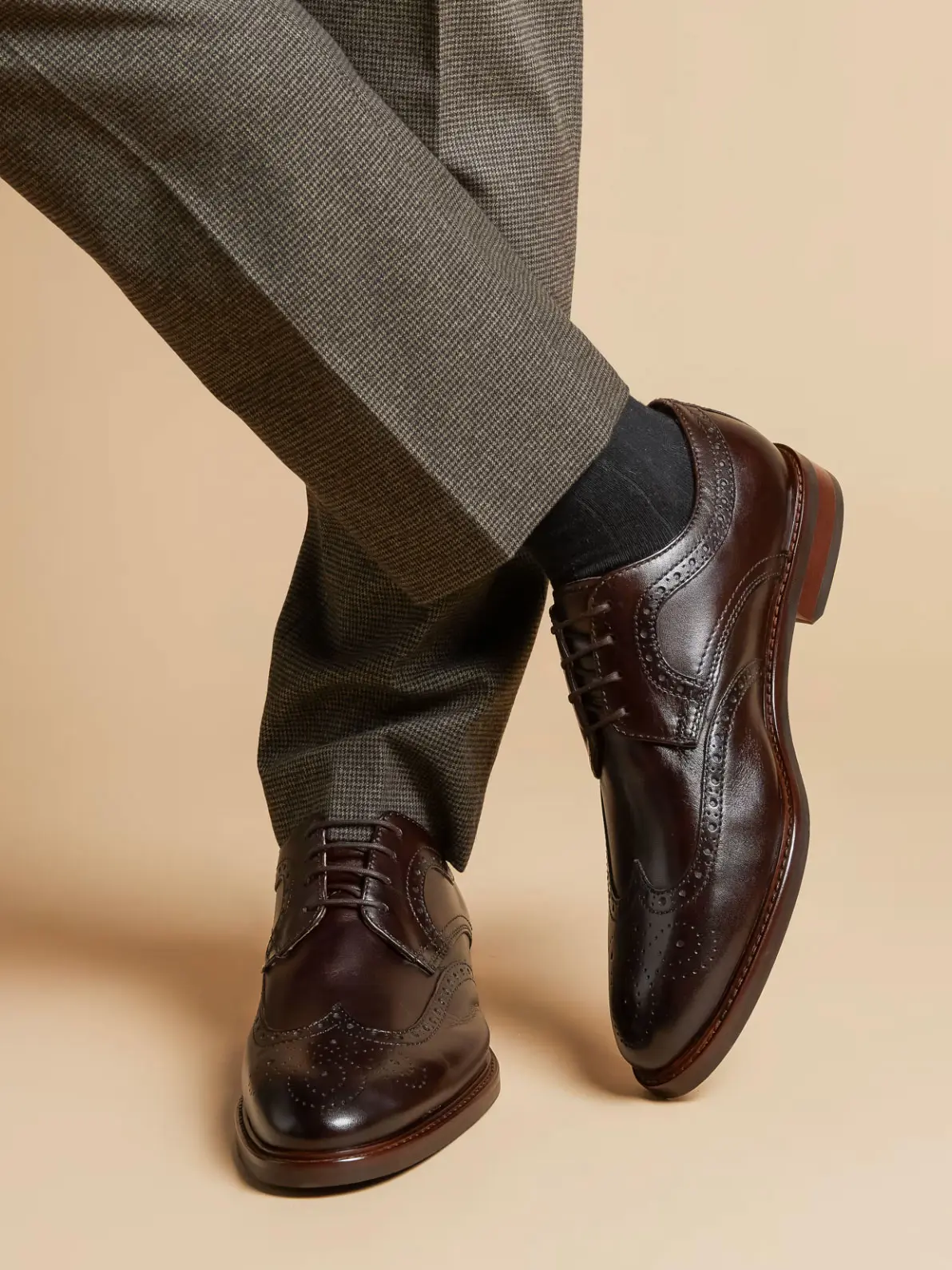 Man wearing smart suit trousers and brown leather brogues