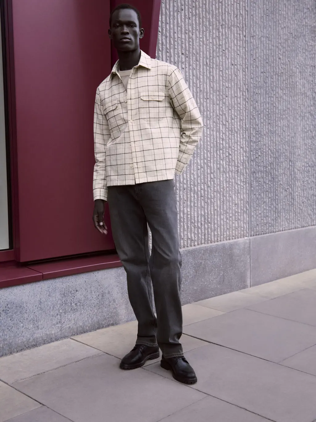 Man wearing black jeans and a checked shacket