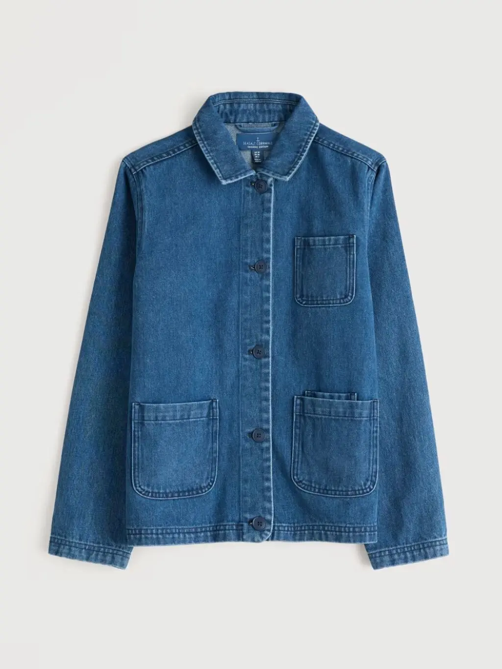 A cutout of a blue shacket shot against a cream background