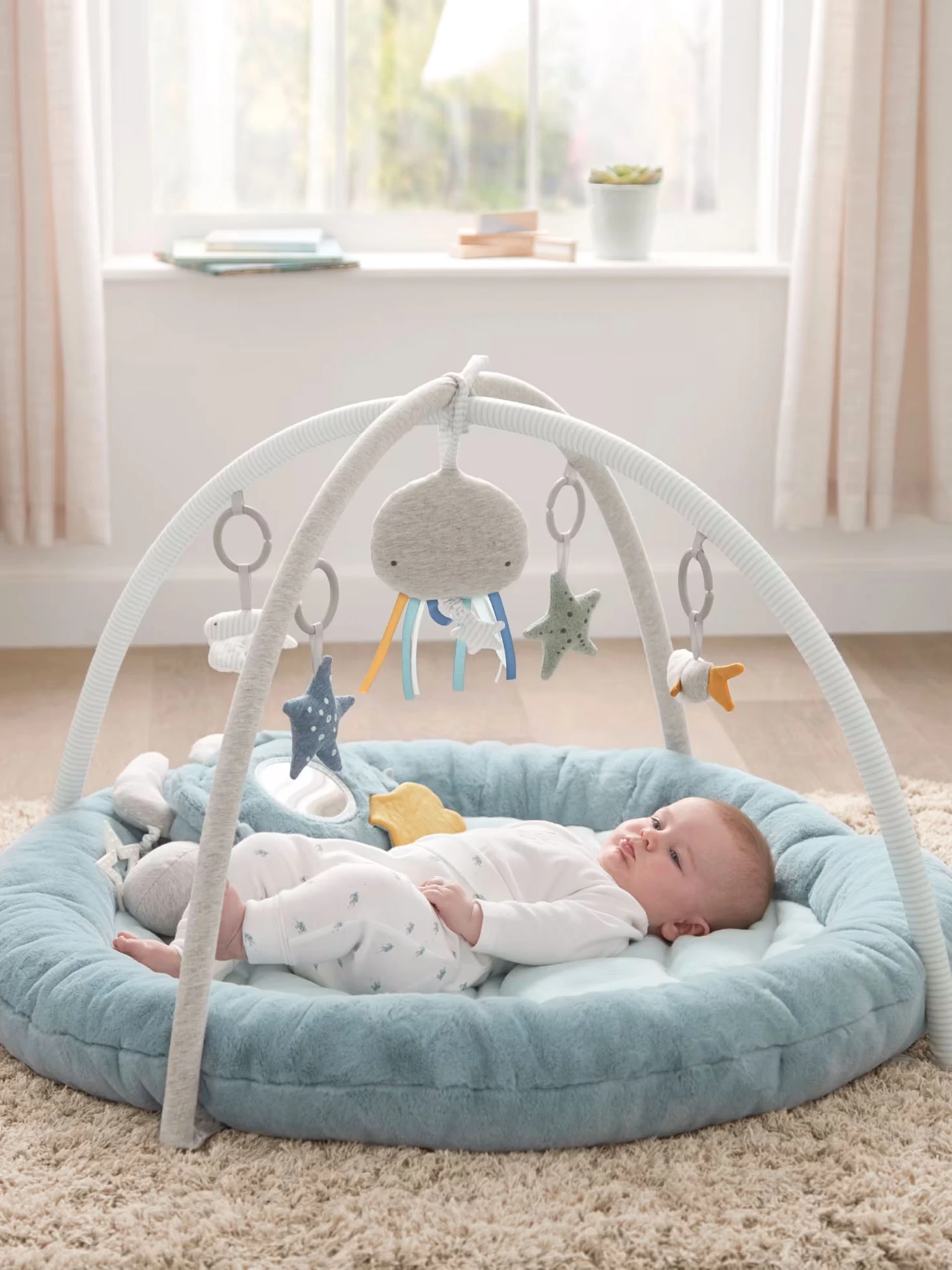 Baby lying in an 'under the sea' themed baby gym by Mamas and Papas